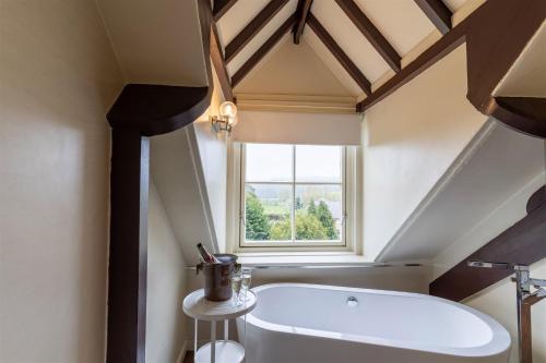 baño con bañera blanca y ventana en Ruswarp Hall - Whitby, en Whitby