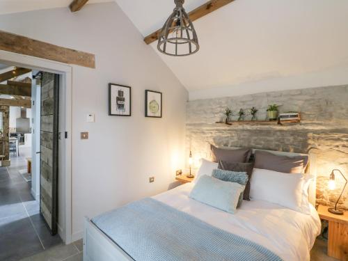 a bedroom with a bed and a stone wall at Freds Shed in Hereford