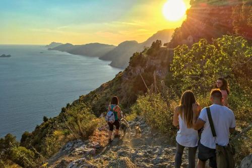 a group of people walking up a hill with a dog at Tenuta Novecento Bioagriturismo in Agerola