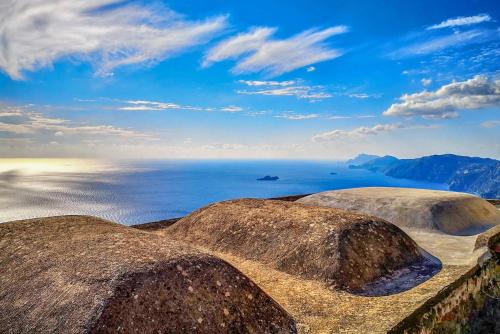 a view of the ocean with rocks in the foreground at Tenuta Novecento Bioagriturismo in Agerola