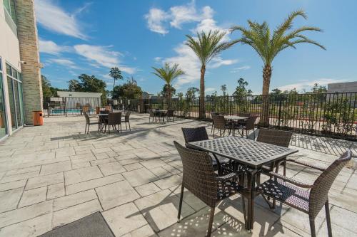 a patio with tables and chairs and palm trees at Holiday Inn Express & Suites Houston - North I45 Spring by IHG in Houston