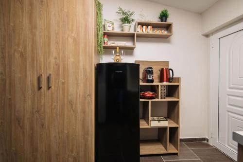 a black refrigerator in a kitchen next to a shelf at Level 3 Sea View Studio in Plános