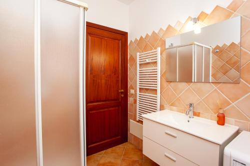 a bathroom with a sink and a mirror at Appartamento Belvedere Citai in San Teodoro