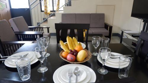 a table with a bowl of fruit on top of it at Tulip Apartment in Ormoc