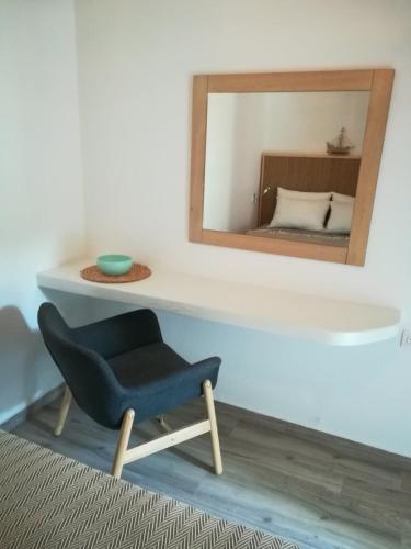 a blue chair in a room with a mirror at Almira Kalamos in Kálamos