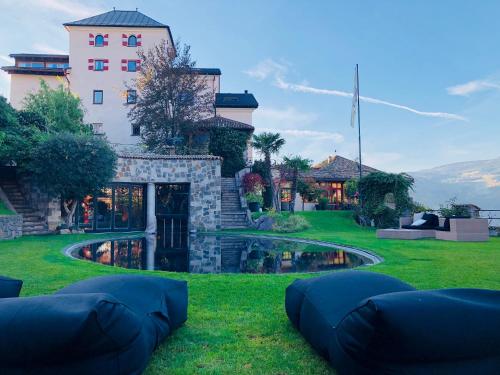 a house with two bean bags in the grass at Romantik Hotel Turm in Völs am Schlern