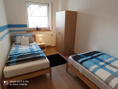 - une petite chambre avec 2 lits et une fenêtre dans l'établissement Ferienwohnung am Hopfengarten, à Illschwang