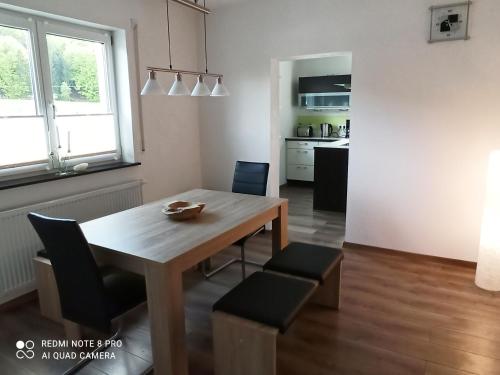 a kitchen and dining room with a wooden table and chairs at Ferienwohnung am Hopfengarten in Illschwang