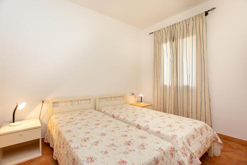 a white bedroom with a bed and a window at Appartamento Belvedere Citai in San Teodoro