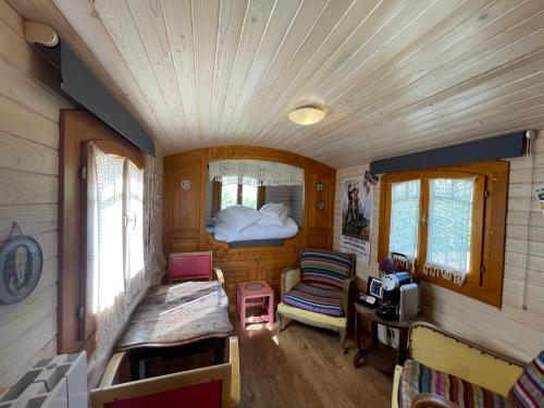 een kleine kamer met een bed in een treinwagon bij Au Presbytère de Saigneville in Saigneville