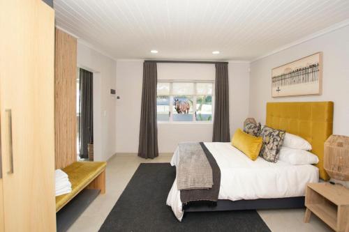 ein Schlafzimmer mit einem Bett mit einem gelben Kopfteil und einem Fenster in der Unterkunft Rubiaceae in Lorraine