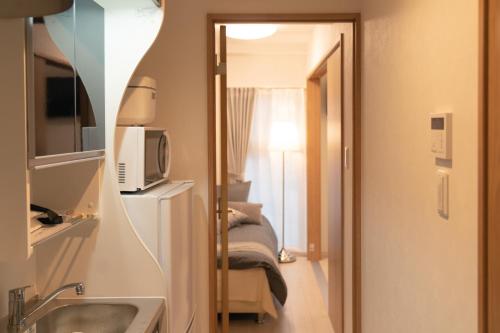 uma casa de banho com um lavatório e um espelho num quarto em OSAKA SUNSHlNE TOWER23 em Osaka