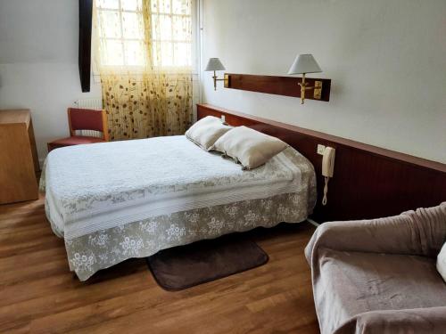 1 dormitorio con 1 cama y 1 sofá en Auberge du val d’ouche, en Bligny-sur-Ouche