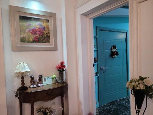 a hallway with a blue door and a table at Jeju Vision House in Jeju