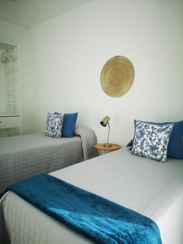 a bedroom with a bed with a blue blanket on it at Villa Montaña Colorada in Lajares