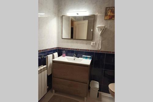 a bathroom with a sink and a mirror and a toilet at Centrico apartamento en Noja con acceso a Spa in Noja