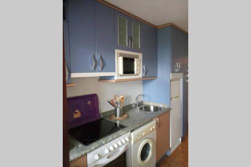 a kitchen with a sink and a microwave at Centrico apartamento en Noja con acceso a Spa in Noja