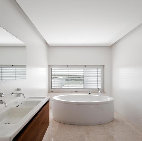 a large white bathroom with two sinks and a tub at Spacious sunset Villa with breathtaking view in Portimão