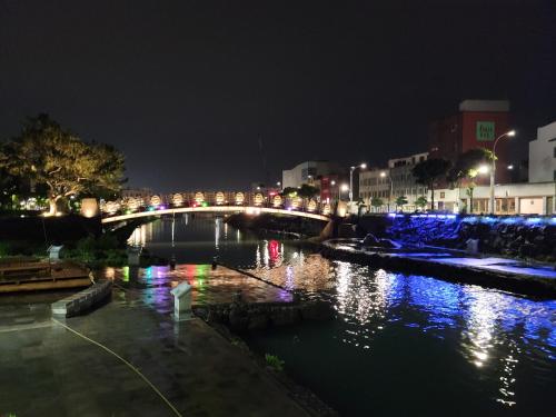 a bridge over a river in a city at night at Jeju Vision House in Jeju