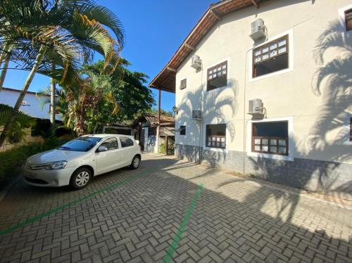 um carro branco estacionado ao lado de um edifício branco em Pousada dos Contos em Paraty