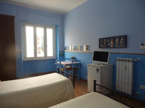 Cette chambre bleue comprend 2 lits et un bureau avec un ordinateur. dans l'établissement Da Nonna Maria B&B, à Rome