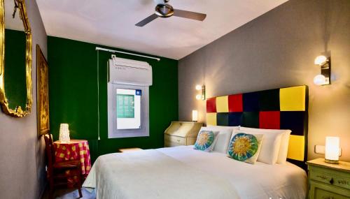 una camera con letto bianco e pareti verdi di Duplex ARTE Apartamento Sitges a Sitges