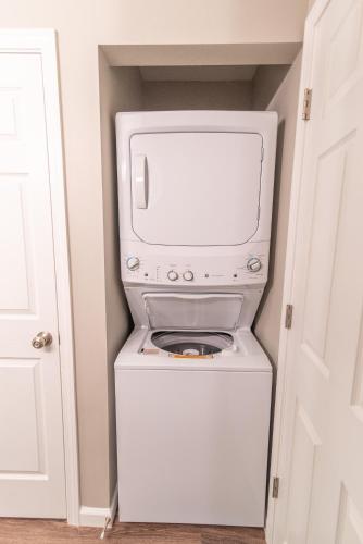 a washer and dryer with a microwave in a closet at Susitna Suites in Wasilla