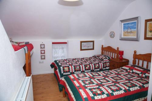 a bedroom with two beds and a window at Cobblers Cottage Creggan in Greencastle