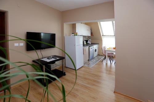 a living room with a white refrigerator and a kitchen at Lazur Sunrise in Burgas