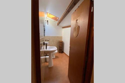 La salle de bains est pourvue d'un lavabo et de toilettes blanches. dans l'établissement Maison de village Chez Mima Valensole, à Valensole