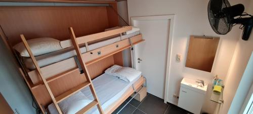 a small room with two bunk beds and a sink at SUN and FUN in Blankenberge