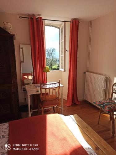 une chambre avec un lit et une fenêtre avec des rideaux rouges dans l'établissement La Maison de Jeanne, à Osse-en-Aspe
