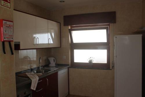 a small kitchen with a sink and a window at Casa das Flores in Vila do Bispo