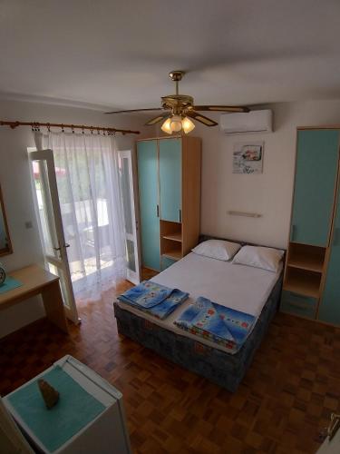 a bedroom with a bed and a ceiling fan at Balen Guest house in Rab