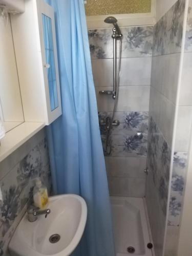 a bathroom with a sink and a shower with a shower curtain at Balen Guest house in Rab