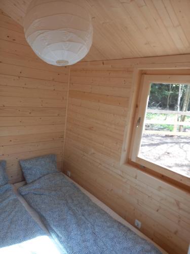 ein Schlafzimmer in einem Blockhaus mit einem Fenster in der Unterkunft HeartSPAce Taszów in Taszów