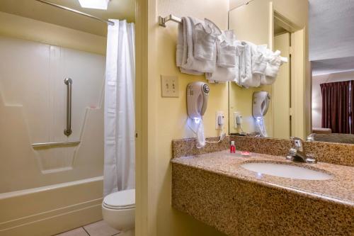 a bathroom with a sink and a toilet and a phone at Econo Lodge Inn & Suites Maingate Central in Kissimmee