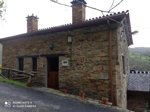 an old stone cottage with a door and a porch at Casa rural "Matela" in Prado