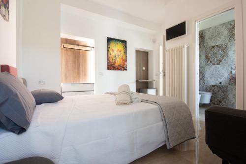 1 dormitorio con cama blanca y baño en B&B IL SOGNO, en Rocca Imperiale