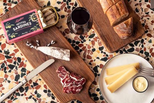 a table topped with a plate of cheese and bread at Hôtel Maison Traversière in Paris