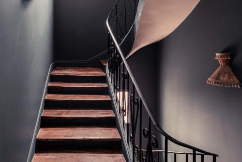 a staircase with black railings and wood treads at Hôtel Maison Traversière in Paris