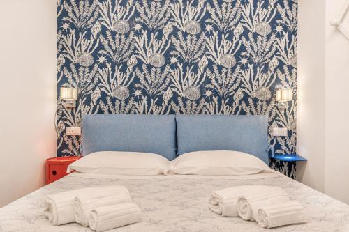 sypialnia z łóżkiem z niebiesko-białą tapetą w obiekcie Blu Mare Apartment w mieście Vernazza