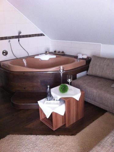 bañera grande en la sala de estar con sofá en Landhaus Waldziegelhütte en Waldmohr