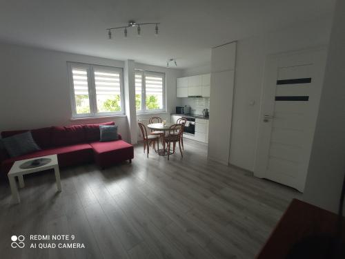 uma sala de estar com um sofá vermelho e uma mesa em Apartament Blisko Zamku em Malbork