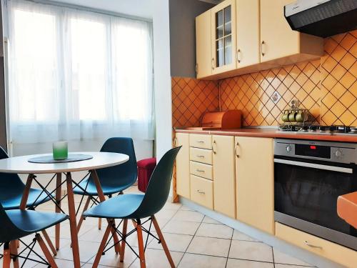 een keuken met een tafel en stoelen en een fornuis bij Bright & Cozy Pula in Pula