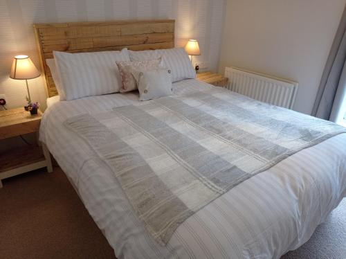 un grande letto in una camera da letto con due tavoli e due lampade di Whitehill Cottage a Castlewellan