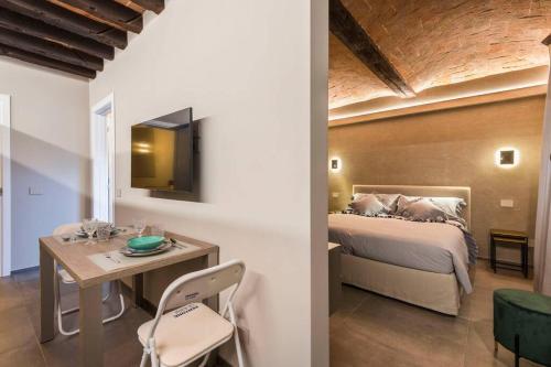 Un dormitorio con una cama, una mesa y un escritorio. en Torre 13, en Módena