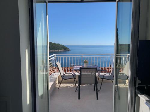 a balcony with a table and chairs and the ocean at Villa Leoni in Dubrovnik