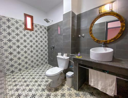 瓦爾扎扎特的住宿－Hotel Riad Amlal，一间带卫生间、水槽和镜子的浴室