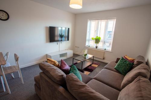 een woonkamer met een bank en een televisie bij Cherry Tree, Centrally Located Warrington Town Centre in Warrington